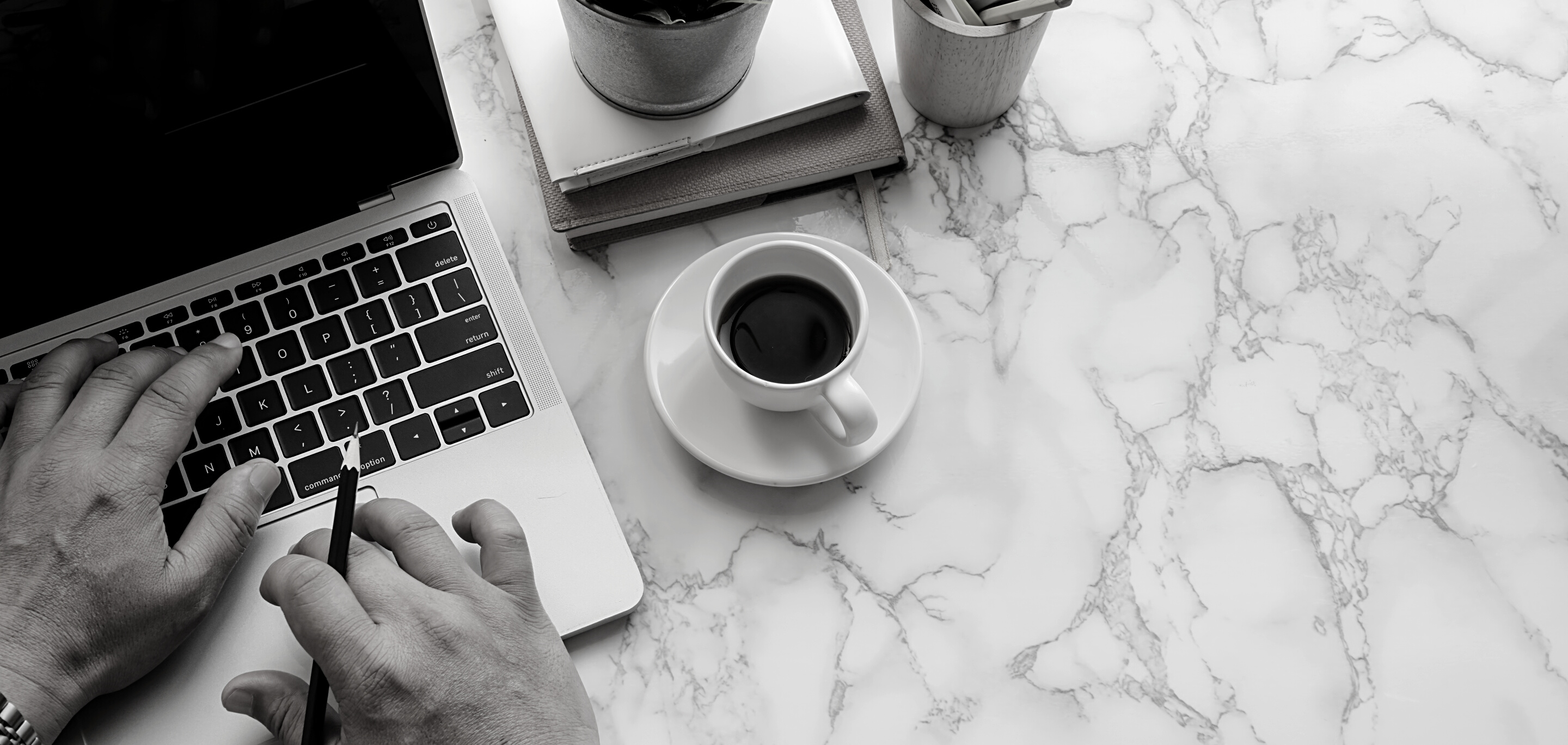 Anonymous man working on laptop having coffee